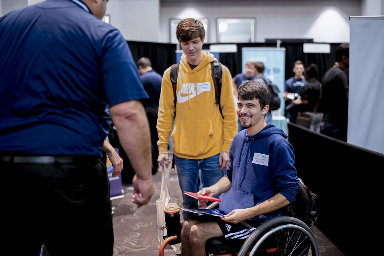 A student smiles at the camera during the career fair